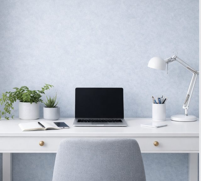 Mesa de trabajo con portátil, plantas y lámpara